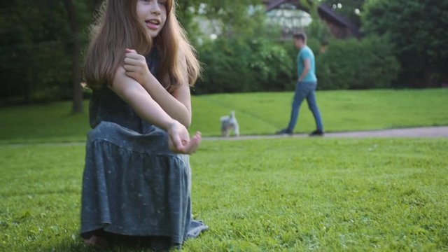 pretty happy teenage girl playing with her puppy outdoors. close-up of a child feeding her bigl dog in the park on summer day.