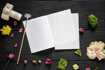 side note pad with a tassel and petal decor on a black charred wooden background, mock up