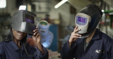4K Portrait young attractive welders with serious, sexy expression. Slow motion.