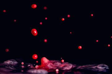A colorful splash of vivid red liquid isolated against a black background