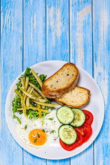 Breakfast - fried egg, toasts and vegetable salad