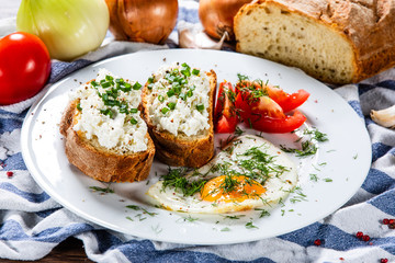 Breakfast - fried egg, toasts and vegetable salad