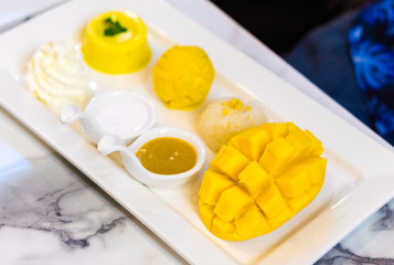 Mango sticky rice in a white dish with selected focus mango.