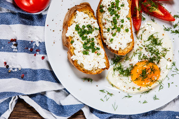 Breakfast - fried egg, toasts and vegetable salad