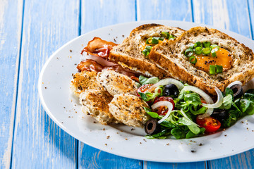 Breakfast - toasted bread with fried egg, bacon and vegetables