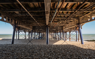 Fototapeta na wymiar Eastbourne Pier, England. An abstract view under the Victorian architecture of the pier in the popular seaside town on the south coast of England.