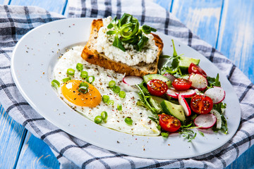 Breakfast - fried egg, toasts and vegetable salad