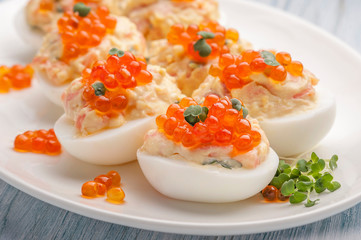 Stuffed eggs with red caviar.