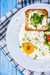 Breakfast - fried egg, toasts and vegetable salad