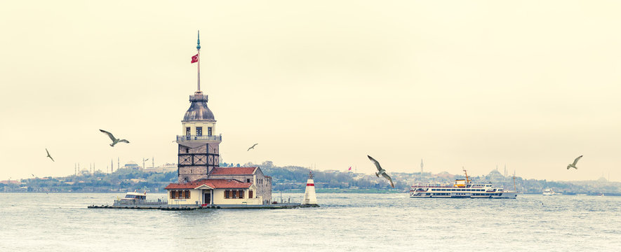Cityscape of Istanbul with Maiden's Tower, wide angle shot for your billboard. Panorama of Bosporus Strait with Kiz Kulesi Tower, seagulls and silhouettes of mosques at skyline.