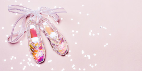 Transparent Holographic Christmas Toy Pointe Shoes and sparkle confetti on pink pastel background