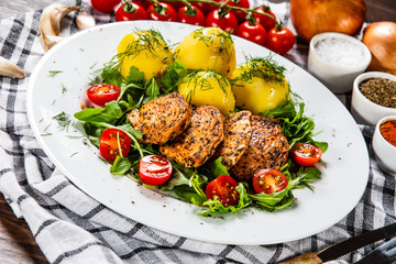 Grilled chicken fillet and vegetables on white plate