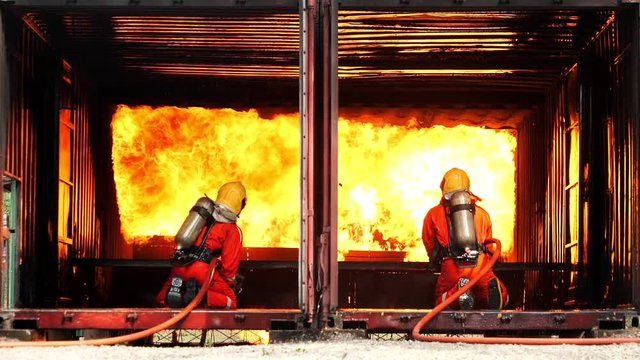 Firemans are using water in fire fighting operation / Fire and firefighter training school.