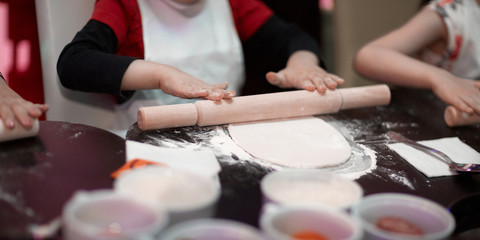 Fototapeta na wymiar close up.a professional chef teaches a little boy to roll out the dough.