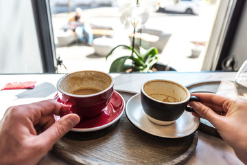 Male and female hand holding empty coffee cups