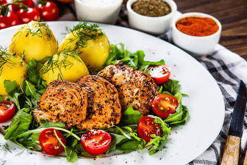 Grilled chicken fillet and vegetables on white plate