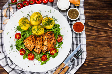 Grilled chicken fillet and vegetables on white plate