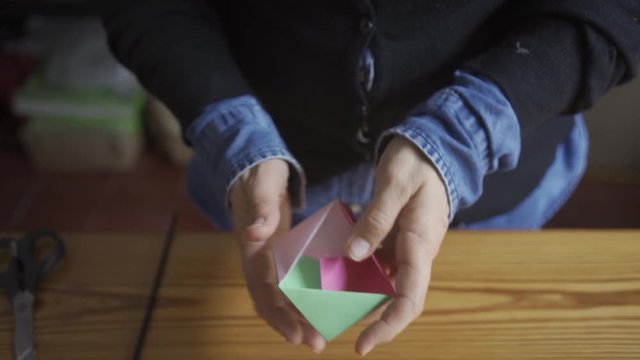 Woman working on origami, some boxes of special gifts for party