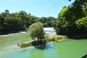 Munich, summer view of Isar river with people sun bathing on the the Praterinsel island