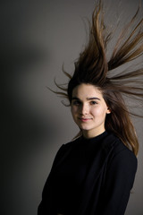 Fototapeta premium Young caucasian girl with brown hair posing on grey background