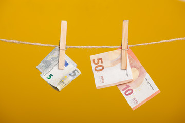 Billetes de euro, colgados de una cuerda sujetos por pinzas de madera de extender la ropa