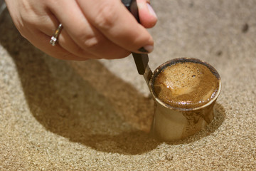 Hand of woman holding pots and making turkish coffee
