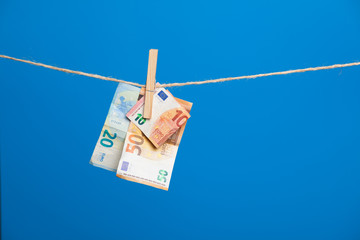 Billetes de euro, colgados de una cuerda sujetos por pinzas de madera de extender la ropa