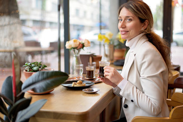 Happy young blonde woman in white suite