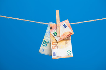 Billetes de Euro colgadois de una cuerda y cogidos por pinzas de madera de extender la ropa