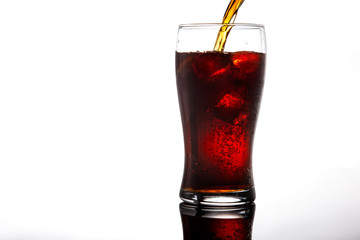 pouring cola into glass with ice on white background Copy space