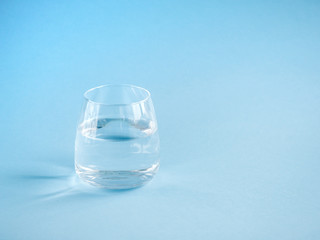 a glass of plain water on a blue background