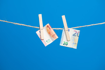 Billetes de Euro colgados de una cuerda y sujetos por pinzas de madera de extender la ropa