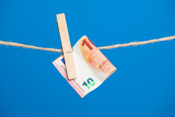 Billetes de Euro colgados de una cuerda y sujetos por pinzas de madera de extender la ropa