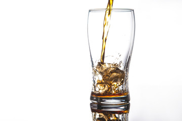 pouring cola into glass with ice on white background Copy space