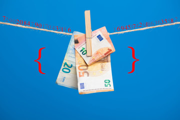 Billetes de Euro sobre fondo azul, colgados de una cuerda y sujetos por pinzas de extender la ropa....