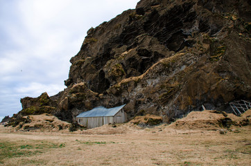 Old stone house destroyed ancient Viking overgrown with yellow dry grass in Iceland