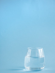 a glass of plain water on a blue background