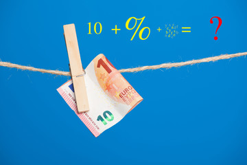 Billetes de Euro sobre fondo azul, colgados de una cuerda y sujetos por pinzas de extender la ropa....