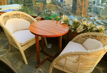 Empty Rattan Chairs with Round Table at the Rooftop Terrace