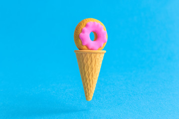 Ice cream cone with doughnut abstract isolated on blue.