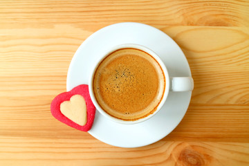 Top view of an espresso coffee with a heart shaped cookies served on wooden table