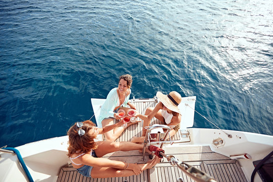 friend’s girl having party on sailing boat and drinking wine top view.