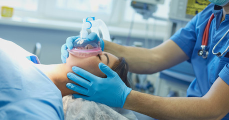 Several doctors surrounding patient on operation table during t