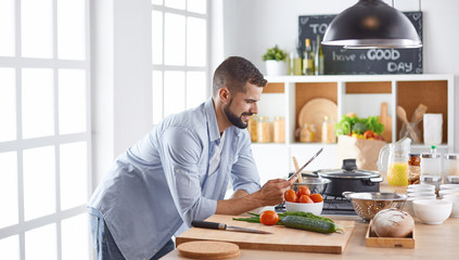 Smiling and confident chef standing in large kitchen