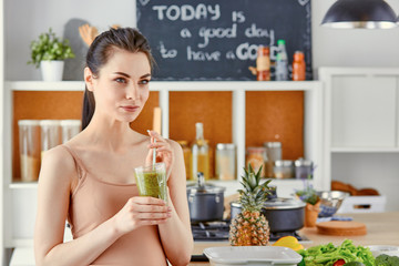 a young girl drinks a cocktail on a kitchen