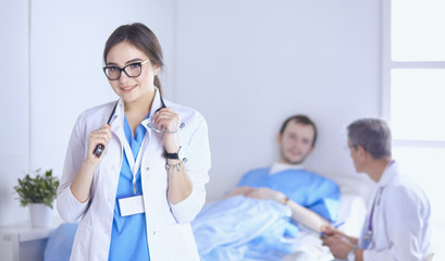 Doctor checking heart beat of patient in bed with stethoscope