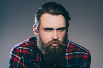 Obraz premium close up. portrait of a stern bearded man in a plaid shirt.