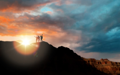travel, tourism and people concept - group of travelers on mountain top over sunset in grand canyon...