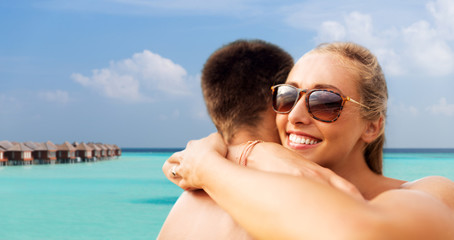 Fototapeta premium summer holidays, vacation and travel concept - happy couple hugging over tropical beach background in french polynesia