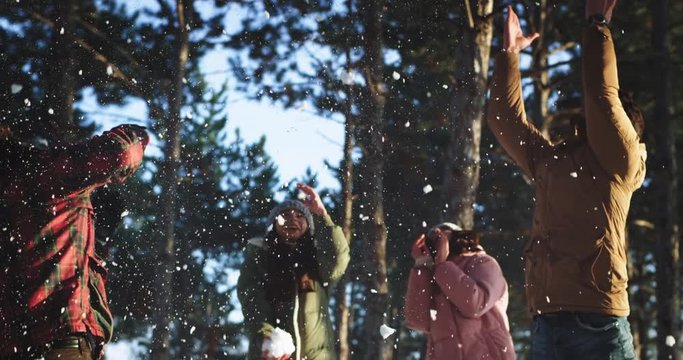 Snow ball time for a multi ethnic group of friends they play funny with the snow ball in the middle of forest enjoying the time together